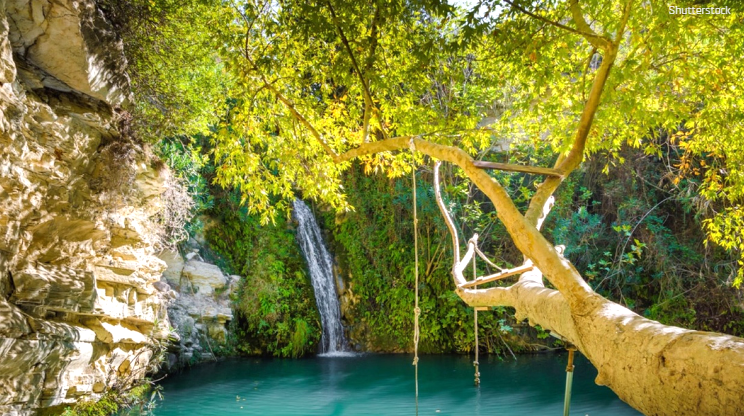 Cyprus natural waterfall with turquoise waters and lush vegetation