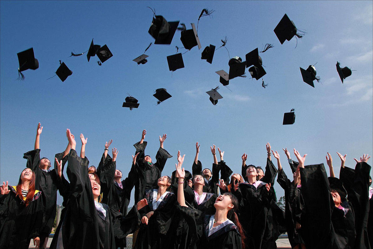 Graduation celebration with students throwing caps in the air